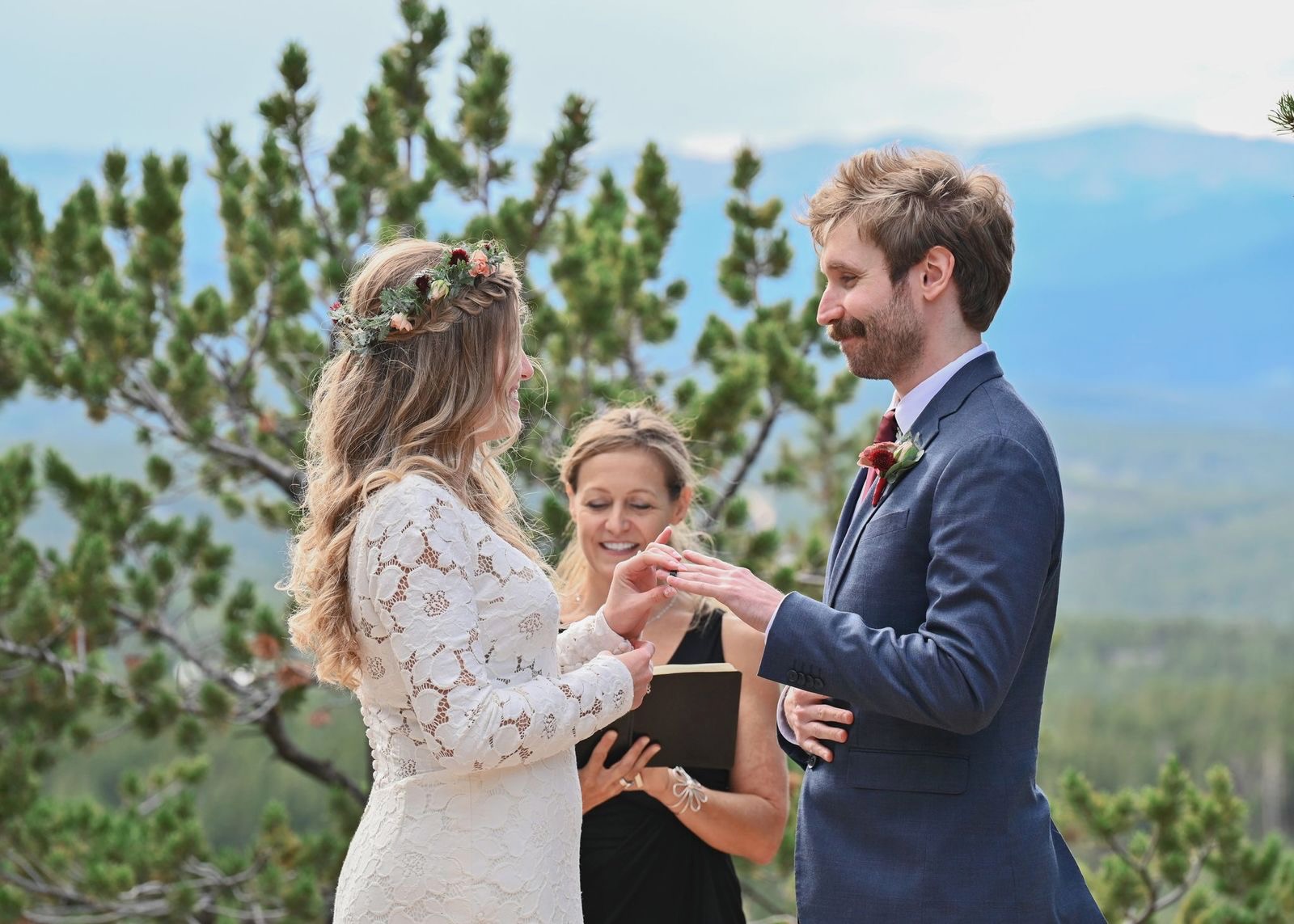 Wendee officiating a wedding as the couple exchange rings outdoors