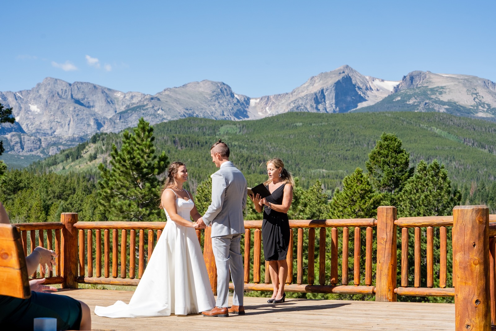 Wendee officiating on a wooden deck with a vast mountain range behind